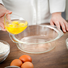 The woman the cook is occupied with dough preparation