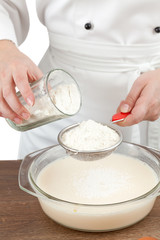 The woman the cook is occupied with dough preparation