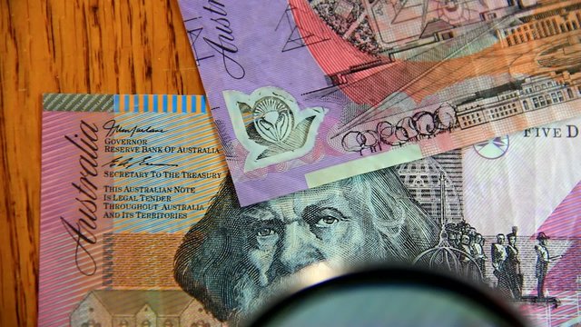 Examining Australian paper money.