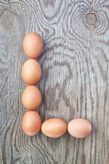 A letter l from the eggs for Easter. On a wooden texture.