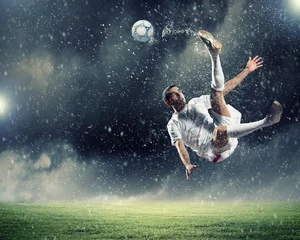Selbstklebende Fototapeten Fußballspieler, der den Ball schlägt © Sergey Nivens