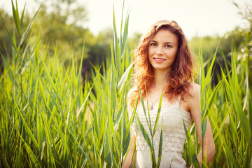 Portrait of beautiful woman in green grass