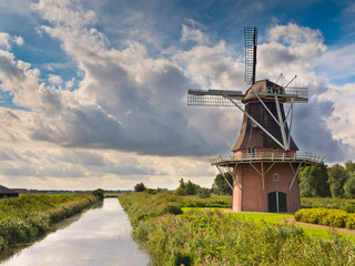 Fototapeta premium Dutch Windmill besides a Canal