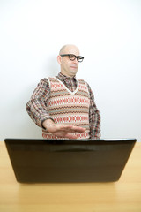 Nerd mit ablehnender Haltung am Laptop