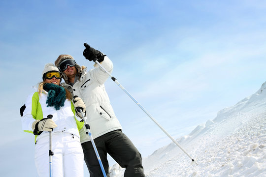 Coupl eof skiers on ski run looking at panorama