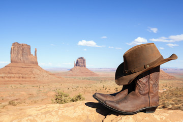 cowboy boots and hat in front of Monument Valley