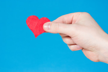 Fototapeta premium Hand with heart on blue background