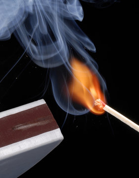 Encendiendo un cerillo,f&oacute;sforo encendido en fondo negro.