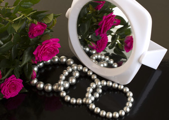 pearl bracelets, bouquet of roses and a mirror