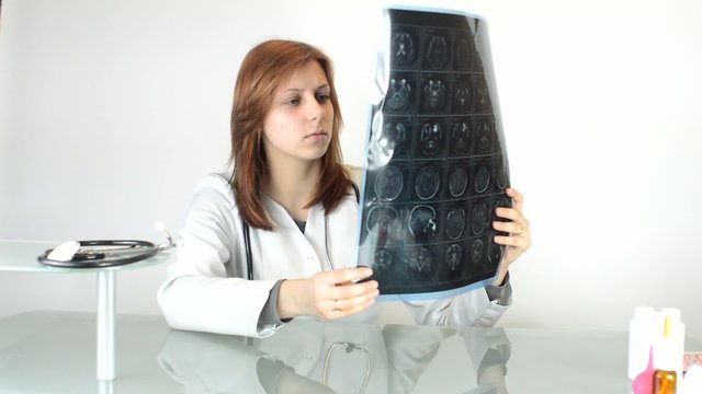 woman doctor carefully considers tomogram