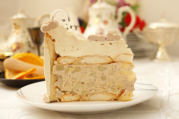 Piece of beige creamy cake with ladyfingers