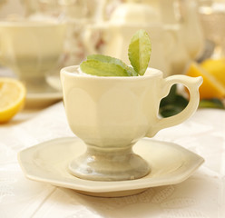 Cup of tea decorated with green leaves