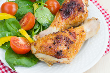 Roasted chicken legs with fresh vegetables salad