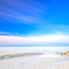 White sand dunes beach, rocks, ocean and sky