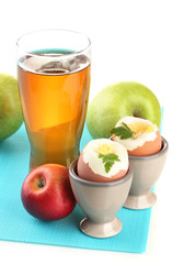 Light breakfast with boiled eggs and glass of juice, isolated