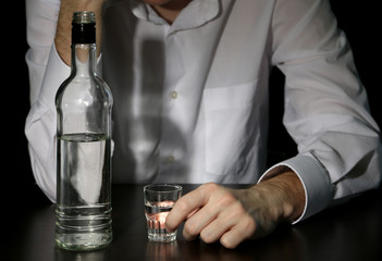 Man with bottle of alcohol,  on black background