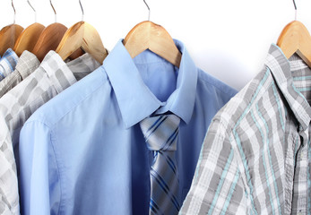 Shirts with ties on wooden hangers isolated on white