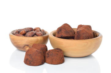 Chocolate truffles and cocoa beans on white background
