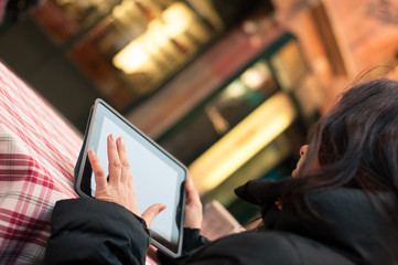 Close up of woman's hand using tablet outdoors. 