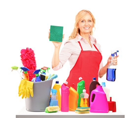 Mature female cleaner posing with cleaning equipment