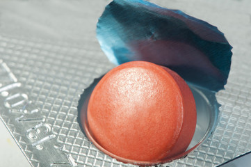 Red pill in a pack very close up