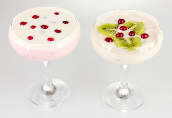 Glasses of yoghurt dessert with fruits and berries, isolated