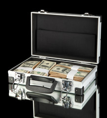 Suitcase with 100 dollar bills on black background