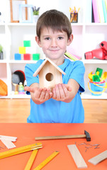 Cute little boy makes birdhouse for birds
