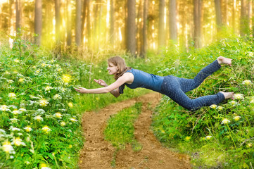 Young woman levitating in the wood - obrazy, fototapety, plakaty
