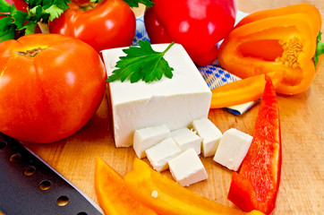 Feta cheese with vegetables on the board