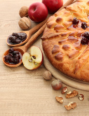 tasty homemade pie with jam and apples, on wooden table