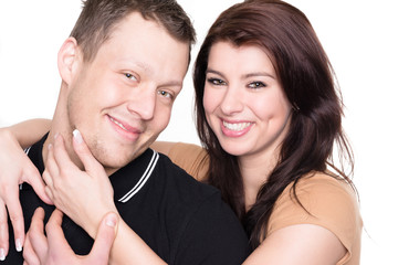 Young and happy couple in front of white background