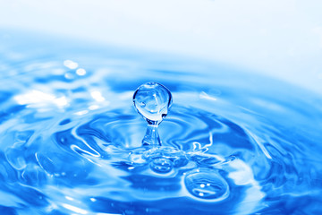 Fototapeta na wymiar Splash of water on blue surface