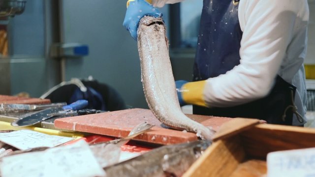 fishmonger in action at marketplace