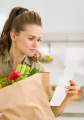 Young housewife examines check after shopping
