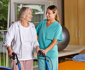 Physiotherapeutin hilft Seniorin mit Rollator