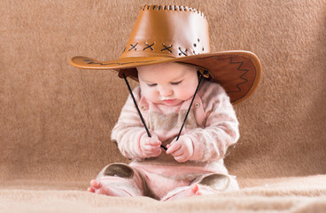 Funny baby in a big cowboy hat