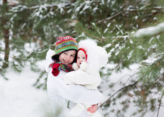 Brother and baby sister walking in snowy winter day forest