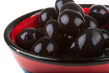 Olives black watered with olive oil in a bowl isolated on a whit