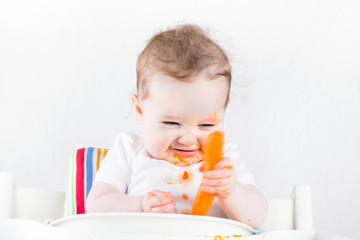 Funny baby trying vegetable first time in her life