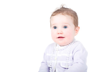Beautiful baby girl in a purple cardigan with a pearl necklace,
