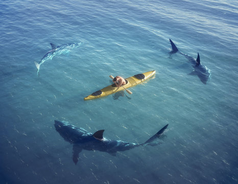 Man on a boat in the middle of the ocean surrounded by sharks.