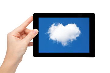 woman hand hold a tablet with blue sky and cloud in the heart of