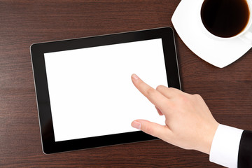 tablet and a cap of caffe on the table and hand of a businessman
