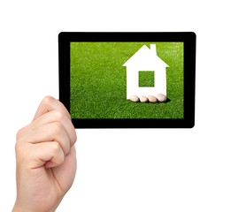 isolated man hand holding a tablet with grass and a house on the