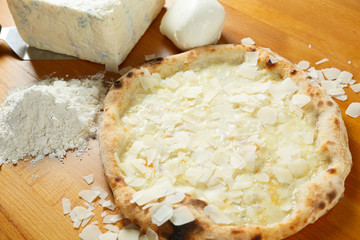 Typical Italian Pizza with ingredients in the background on a wo