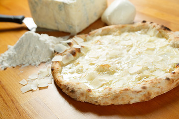 Typical Italian Pizza with ingredients in the background on a wo