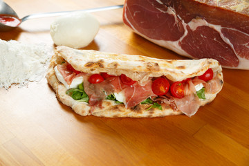 Typical Italian Pizza, ingredients in background on wood table