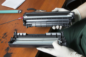 hands repairing laser toner cartridge