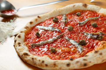 Pizza italienne typique, ingrédients en arrière-plan sur table en bois